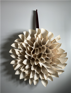 dahlia wreath made out of book pages handing on wall